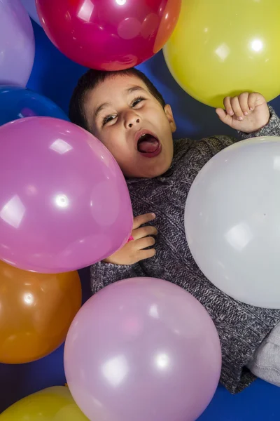 Kind spielt mit bunten Luftballons — Stockfoto