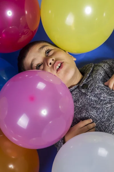 Criança brincando com balões coloridos — Fotografia de Stock
