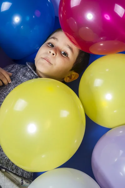 Criança brincando com balões coloridos — Fotografia de Stock