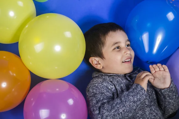 Enfant jouant avec des ballons colorés — Photo