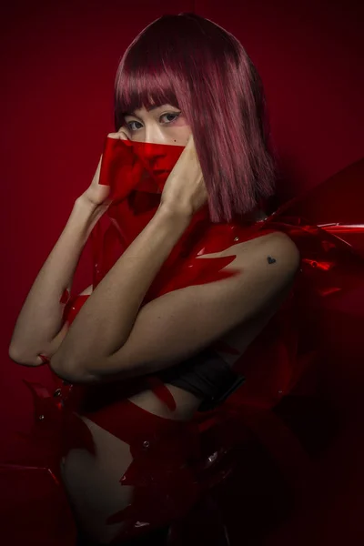Oriental chica con traje de plástico rojo —  Fotos de Stock