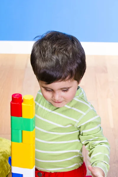 Menino brincando com blocos coloridos de plástico — Fotografia de Stock