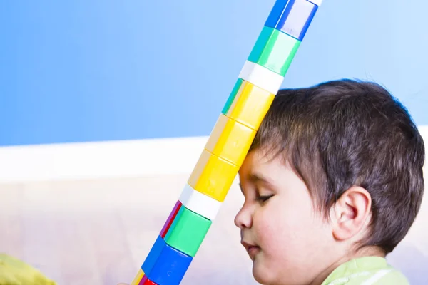 Menino brincando com blocos coloridos de plástico — Fotografia de Stock