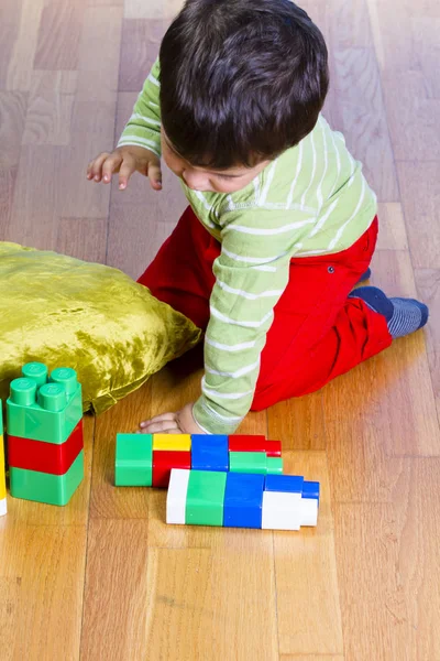 Boy playing with plastic colorful blocks — Stock Photo, Image