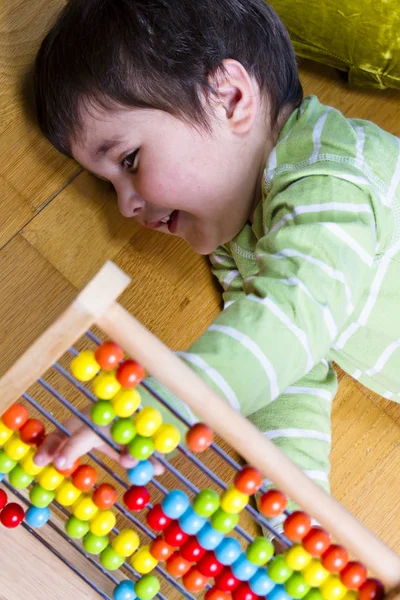 Vicces kisfiú játszik az abacus — Stock Fotó