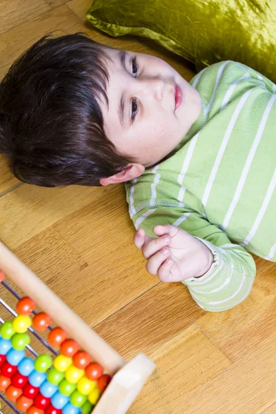 Funny little boy playing with abacus — Stock Photo, Image