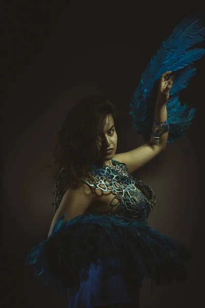 Beautiful latin woman in blue feather bird costume