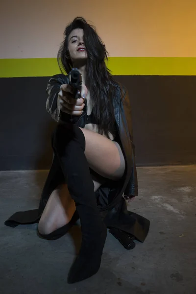 Army brunette girl with gun in a garage — Stock Photo, Image