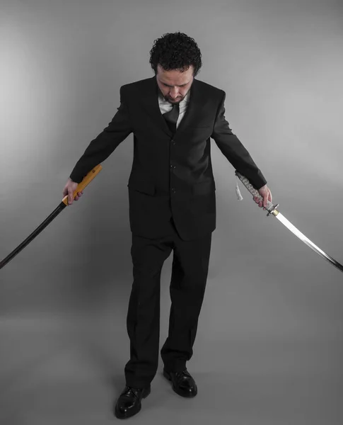 Агрессивный бизнесмен с японскими мечами — стоковое фото