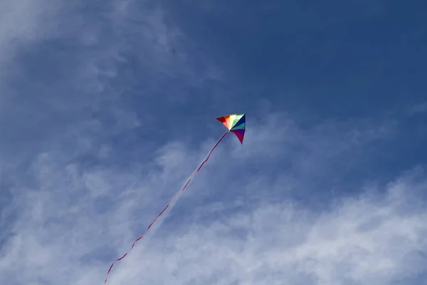 Kite of rainbow colors in sky — Stock Photo, Image