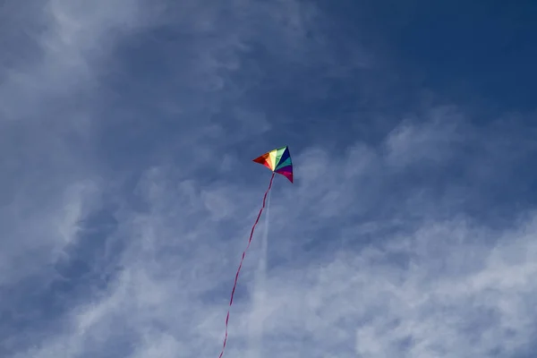 Kite of rainbow colors in sky — Stock Photo, Image