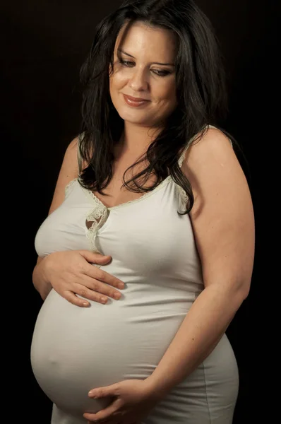 Schwangere brünette Frau in heller Kleidung — Stockfoto