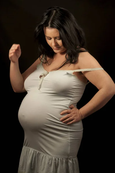 Schwangere brünette Frau in heller Kleidung — Stockfoto