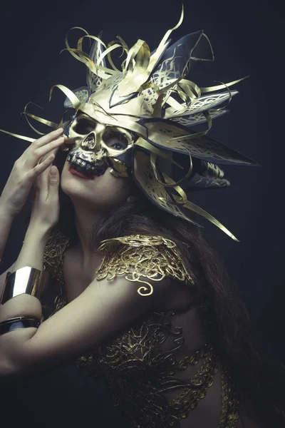 Mädchen in goldenem Kleid und Maske — Stockfoto