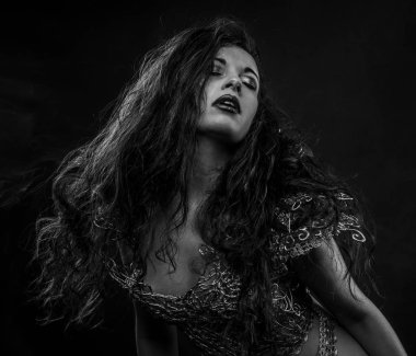 esmer kadın altın konu ve kafatası maskeli bir elbise ile Gotik tarzda giyinmiş