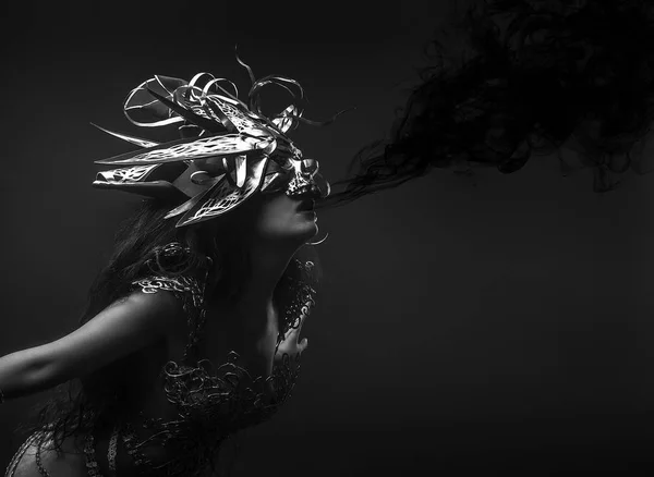 Kraliçe, siyah duman, esmer kadın altın konu ve kafatası maskeli bir elbise ile Gotik tarzda giyinmiş