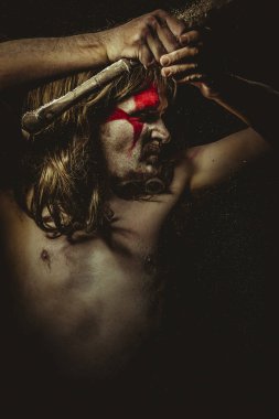 Yüz, uzun saç metal kılıç ve savaş boya ile vahşi savaşçı