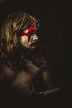 Yüz, uzun saç metal kılıç ve savaş boya ile vahşi savaşçı