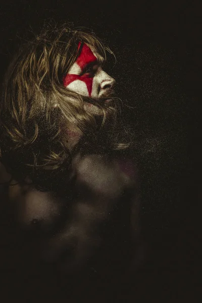 Tribe, Wild warrior with metal sword and war paintings on the face, long hair