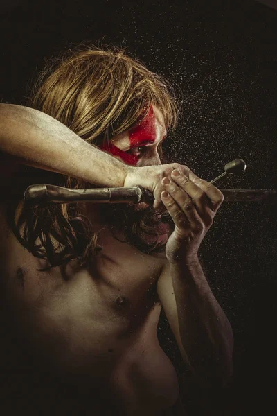 Yüz, uzun saç metal kılıç ve savaş boya ile vahşi savaşçı