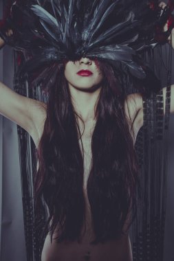 Parti, şehvetli ve gizemli teşkil büyük tüyleri yapılmış bir headdress çıplak esmer kadın