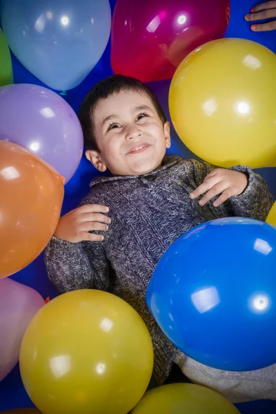 笑顔し 誕生日パーティーで喜びをカラフルな風船で遊ぶブルネットの少年 — ストック写真