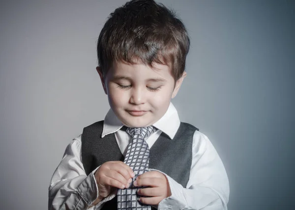 最初の雇用 小さなビジネスマン 茶色の髪の少年に身を包んだスーツし 顔と面白い表現を持つネクタイ — ストック写真