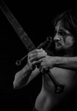 Yüz, uzun saç metal kılıç ve savaş boya ile vahşi savaşçı