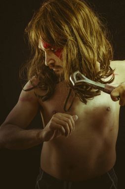 Kahraman, yüz, uzun saç metal kılıç ve savaş boya ile vahşi savaşçı