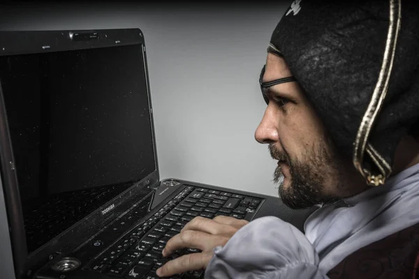 Man in pirate clothes, attempt to hack a laptop