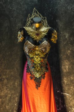 fantastik altın zırh ve el yapımı metal parçalar, Gotik parçaları ve kırmızı tüyler bir kask ile bir altın ejderha ölçekli zırh vardır, bu kırmızı etek ve takı metal parçaları