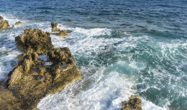 Yanında Akdeniz Turizm cliff, güçlü dalgalar kayalar ile break ve mavi ve turkuaz renkleri ile birlikte denizin köpük bırakın.