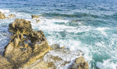 Yaz cliff Akdeniz yanında, güçlü dalgalar kayalar ile break ve mavi ve turkuaz renkleri ile birlikte denizin köpük bırakın.