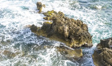 Cliff Akdeniz yanında, güçlü dalgalar kayalar ile break ve mavi ve turkuaz renkleri ile birlikte denizin köpük bırakın.