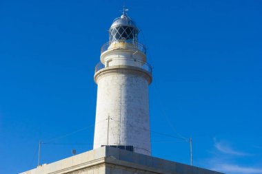 yanındaki mavi gökyüzü olmadan sakin suları ile bulutlar deniz deniz feneri. gemi kayalara varlığının uyarmak için hizmet vermektedir