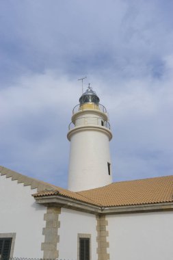 yanındaki mavi gökyüzü olmadan sakin suları ile bulutlar deniz deniz feneri. gemi kayalara varlığının uyarmak için hizmet vermektedir