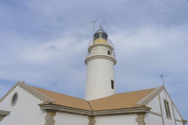 yanındaki mavi gökyüzü olmadan sakin suları ile bulutlar deniz deniz feneri. gemi kayalara varlığının uyarmak için hizmet vermektedir