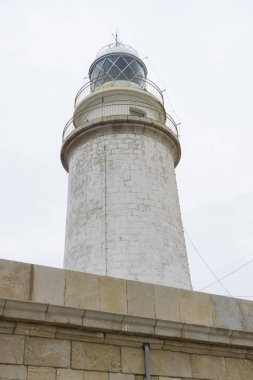 yanındaki mavi gökyüzü olmadan sakin suları ile bulutlar deniz deniz feneri. gemi kayalara varlığının uyarmak için hizmet vermektedir