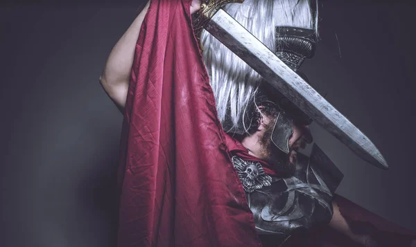 罗马角斗士 摔跤手和罗马勇士用头盔和红色斗篷 运载一把铁剑 胡子和长发 — 图库照片