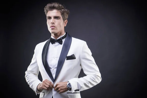 Stylish Luxury, elegant man in a white suit tuxedo with bow tie around his neck