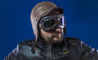 20'li yaşlarda güneş gözlüğü ve vintage havacı kask ile pilot. Ceket, sakal ve anlamlı yüzler giyer deri