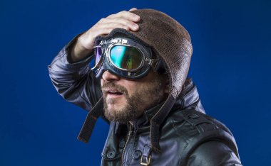 20'li yaşlarda güneş gözlüğü ve vintage havacı kask ile pilot. Ceket, sakal ve anlamlı yüzler giyer deri