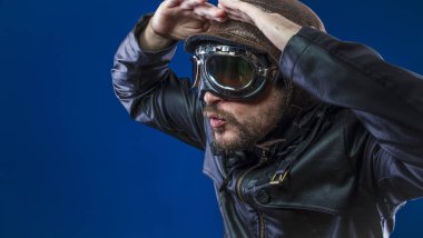 Pilot 20s güneş gözlüğü ve vintage havacı kask ile keşfedin. Ceket, sakal ve anlamlı yüzler giyer deri