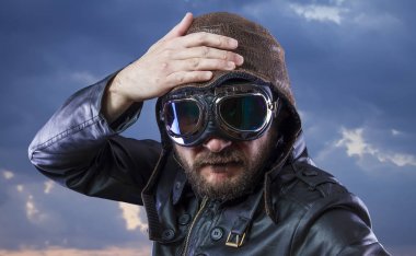 20'li yaşlarda güneş gözlüğü ve vintage havacı kask ile pilot. Ceket, sakal ve anlamlı yüzler giyer deri