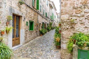 rustic, flowerpots street in the tourist island of Mallorca, Valdemosa city in Spain clipart