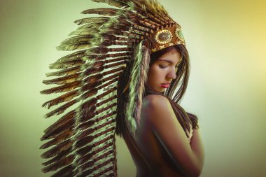 Etnik, genç ve güzel esmer, büyük Amerikan kızılderili tüyü tüyü var. Uzun siyah saçları var.