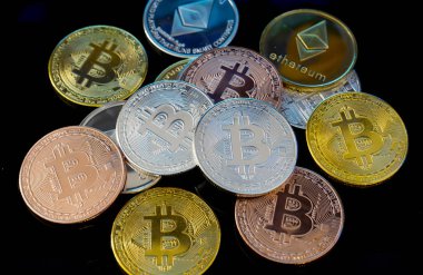 Bitcoin altın, gümüş ve bakır paralar ve çözülmüş baskılı devre arka planı. Sanal kripto para birimi kavramı.