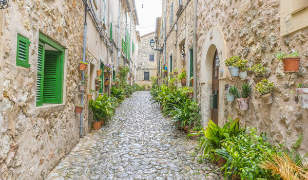 Beautiful street in Valldemossa with traditional flower decoration, famous old mediterranean village of Majorca. Balearic island Mallorca, Spain