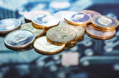 Bitcoin altın, gümüş ve bakır paralar ve çözülmüş baskılı devre arka planı. Sanal kripto para birimi kavramı.