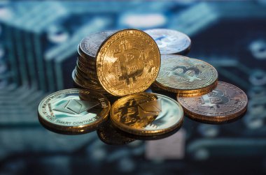 Bitcoin altın, gümüş ve bakır paralar ve çözülmüş baskılı devre arka planı. Sanal kripto para birimi kavramı.